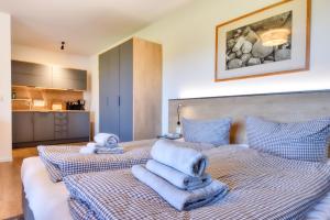 a bedroom with a bed with towels on it at Ferienwohnung Eiderente 29 im Wreecher Idyll Rügen by ruyastay in Putbus