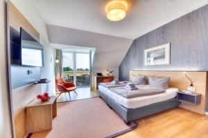 プットブスにあるFerienwohnung Wiesenpieper 07 im Wreecher Idyll Rügen by ruyastayのベッドと椅子とテレビのある寝室