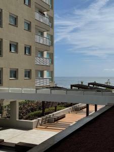 a building with a walkway next to the ocean at Summer Holiday com Piscina Climatizada - Piçarras in Piçarras