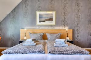 a bedroom with a bed with blue pillows on it at Ferienwohnung Mauersegler 14 im Wreecher Idyll Rügen by ruyastay in Putbus