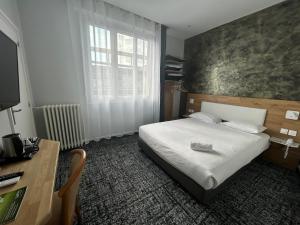 Кровать или кровати в номере Brit Hotel Privilège Le Royal - Centre Gare
