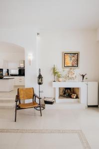 a living room with a chair and a fireplace at MareEterno in Ios Chora