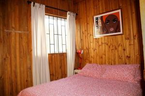a bedroom with a bed and a picture on the wall at Cabaña Roja in La Laguna