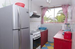 a kitchen with a white refrigerator and red cabinets at Cabaña Roja in La Laguna