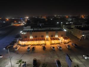 a building with cars parked in a parking lot at night at Hotel Aloe Emira NKC in Nouakchott