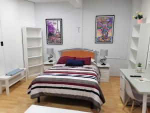 a white bedroom with a bed and a desk at Encantadoras Habitaciones Privadas Del Valle in Mexico City