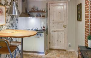 a small kitchen with a table and a stove at 2 Bedroom Gorgeous Home In Virserum in Virserum +12 photos