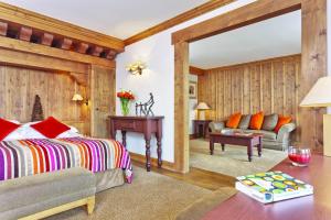 a bedroom with a bed and a living room at Hôtel Les Barmes De l'Ours in Val-d'Isère +37 photos