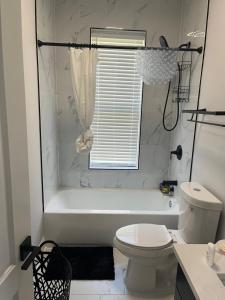 a white bathroom with a tub and a toilet at Mixed Rustic Vibes in Chicago