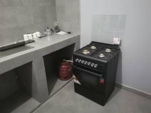 a kitchen with a stove and a counter with a sink at Appartement chez Alioune in Tilel +3 photos