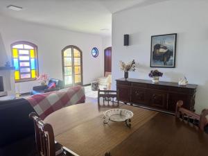 un salon avec un canapé et une table dans l'établissement Casa com lareira em São Bento, à São Bento do Sapucaí