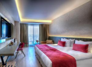 a hotel room with a large bed with red pillows at The X Belek in Belek