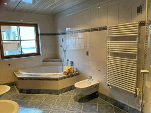 Un baño con bañera, inodoro y lavabo. en Buck Chalet, en Steeg 10 fotos más