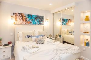 ein Schlafzimmer mit einem weißen Bett mit Handtüchern darauf in der Unterkunft Casa Zen in Azenhas do Mar