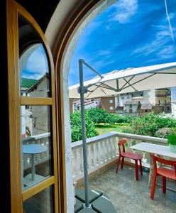 un balcone con tavolo e ombrellone di Casa El Caney en Corazón de La Vera a Villanueva de la Vera