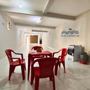 un tavolo rosso e sedie in una stanza di Casa grande no centro em Camocim CE a Camocim