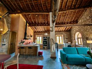 un soggiorno con un divano blu e una cucina di Casa El Caney en Corazón de La Vera a Villanueva de la Vera