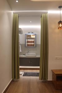un bagno con lavandino e specchio di The Grove a Devikolam