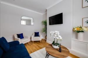 a living room with a blue couch and a table at Royal Chester Retreat - Rose Platinum Properties in Chester