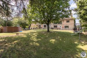 a park with a tree and a playground at Gîte des moulins in Castelnau-dʼEstrétefonds