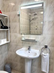 ein Badezimmer mit Waschbecken und Spiegel in der Unterkunft Casa De Baixo in Lissabon