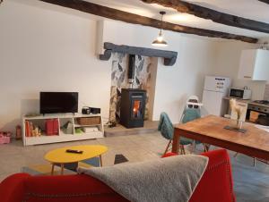 a living room with a couch and a table and a fireplace at Maison atypique et charmante in Pleugueneuc
