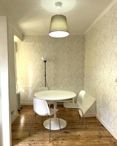 ein Esszimmer mit einem weißen Tisch und Stühlen in der Unterkunft Casa De Baixo in Lissabon