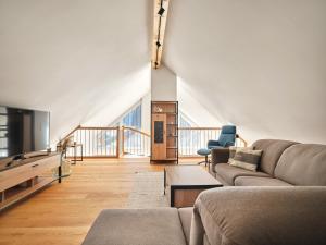 a living room with a couch and a tv at Gipfelblick Lodge 5 Pruggern by AA Holiday Homes in Pruggern
