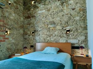 una camera da letto con un muro in pietra con un letto di Casa El Caney en Corazón de La Vera a Villanueva de la Vera
