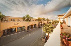 an empty street with palm trees in front of a building at Amelius Pool Apartments in Caesar Resort SPA, Long Beach in Perivolia tou Trikomou