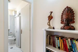 a book shelf with books and a mask on it at La Casina Gialla Independent House in Lucca +14 photos