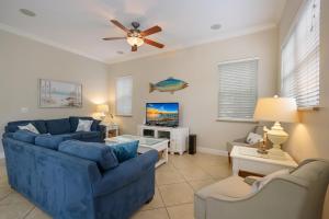 a living room with two blue couches and a tv at Margarita-Ville in Holmes Beach