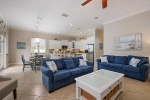 a living room with blue couches and a kitchen at Margarita-Ville in Holmes Beach