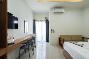 碧差汶T-OneHome的一间带床、桌椅的酒店房间