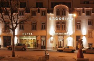 un bâtiment avec des voitures garées devant lui dans l'établissement Hotel Bagoeira, à Barcelos