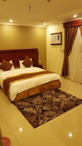 a bedroom with a large bed and a rug at AL manzil ALmutmeez in Jeddah