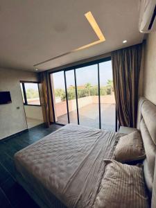 a bedroom with a large bed with a large window at Villa MK in Aghmat +17 photos
