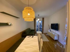 a living room with a table and a couch at Cozy one bedroom apartment in Podgorica