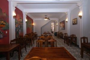 Un restaurante con mesas y sillas en una sala. en Jade Hotel, en Hue