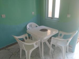 a white table and chairs in a room at Studio avec cuisine - kitchen in Tinerhir