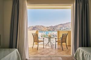 a dining room with a table and chairs and a window at Lindos Royal Resort in Líndos