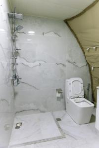 een witte badkamer met toilet en douche bij Dream Domes Glamping House in Gabala