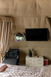 een slaapkamer met een bed, een tv en een stoel bij Dream Domes Glamping House in Gabala