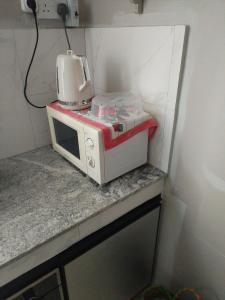 a microwave sitting on top of a counter at Sleepy East Homestay in Lalmatie