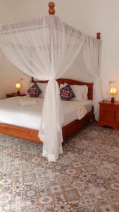 a bedroom with a bed with a canopy at Home Villa in Lovina +4 photos