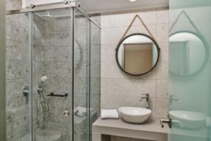 een badkamer met douche, wastafel en spiegel bij Villa Danae Periyali in Vasilikos +21 foto's
