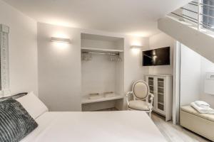 a white bedroom with a bed and a chair at Elegant flat in the Historic Rome near Colosseum! in Rome