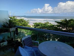 a balcony with a table and a view of the beach at PITANGUEIRAS LINDO FRENTE AO MAR 4 QUARTOs in Guarujá