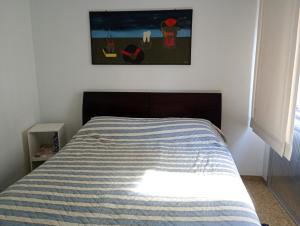 a bedroom with a bed with a striped blanket at PITANGUEIRAS LINDO FRENTE AO MAR 4 QUARTOs in Guarujá