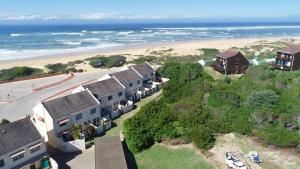 an aerial view of a beach with houses and the ocean at 8 Settler Sands Ocean View in Port Alfred +21 photos